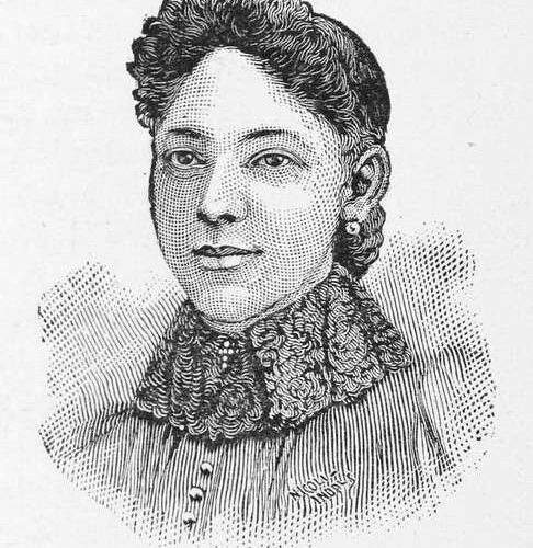 Georgia De Baptiste in a sketch or engraving of her bust. Her hair is stilled in a curled bouffant bang in the front with the rest of her hair pulled back in a bun. She wears a lace collar with a top that has several buttons fastened. Beneath the photo is “Georgia M. Debabtiste.”