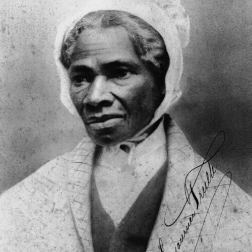 Black and white photo of Sojourner Truth. Facial photo. She is wearing a white coat, black vest and white button shirt and a white bonnet on her head