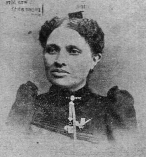 Black and white portrait of Mary Small. She is wearing her curly hair pulled to the back. She is wearing a large necklace.