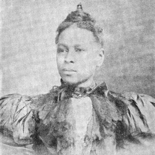 Virginia E. Walker Broughton, wearing her hair up and a fancy frilled jacket with a high collar. The photo is in black and white.