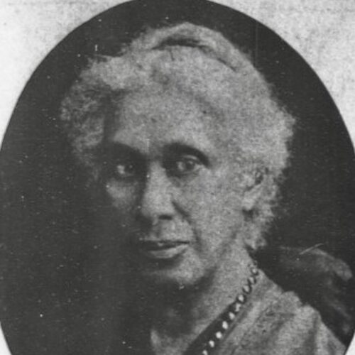 Elizabeth Lindsay Davis wearing her light hair pulled back with a necklace. The photo is in black and white.
