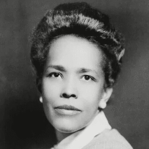 Ella Baker wearing her hair up, with earrings and a collar-jacket. The photo is in black and white.