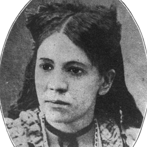 Fannie Jackson Coppin in black and white in an oval frame with white background. Fannie’s hair is parted in the middle, pulled back and down her back. She is looking toward her right, wearing a ruffled top with a dark colored choker and pendant.