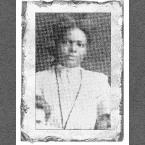 Lucy Farrow wearing her hair parted in the middle and pulled back, with a long necklace, and a light colored high collared top or dress. The photo is in black and white.